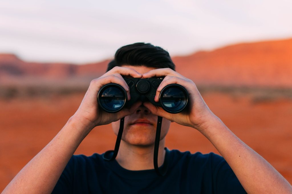 rapas olhando o horizonte com um binóculo